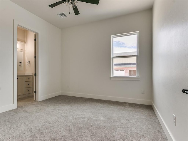 unfurnished bedroom featuring connected bathroom, carpet floors, a ceiling fan, visible vents, and baseboards