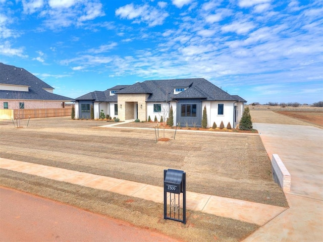 view of front of property featuring roof with shingles and fence