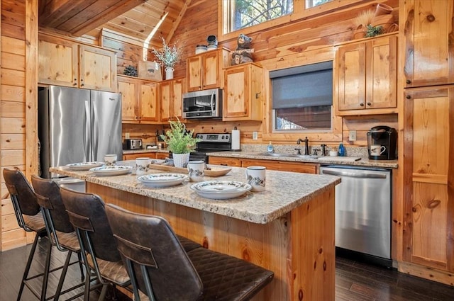 kitchen featuring a center island, dark hardwood / wood-style flooring, wood walls, wood ceiling, and appliances with stainless steel finishes