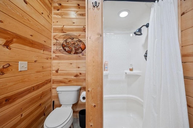 bathroom featuring wood walls, toilet, and walk in shower