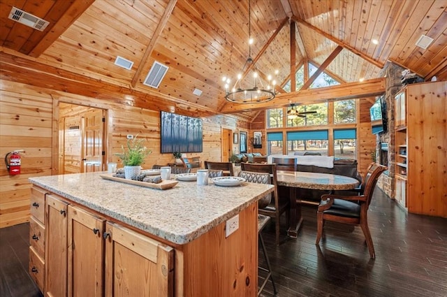 kitchen featuring wood walls, a center island, wood ceiling, and a chandelier