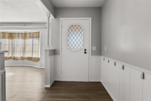 doorway featuring a textured ceiling and dark wood-type flooring