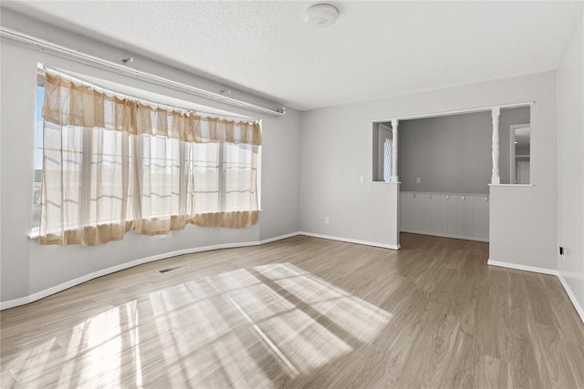 empty room with wood-type flooring and a textured ceiling