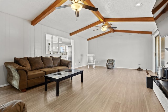 living room featuring ceiling fan, lofted ceiling with beams, a textured ceiling, and light hardwood / wood-style floors