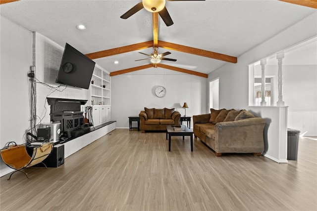 living room featuring ornate columns, ceiling fan, vaulted ceiling with beams, built in features, and light hardwood / wood-style floors