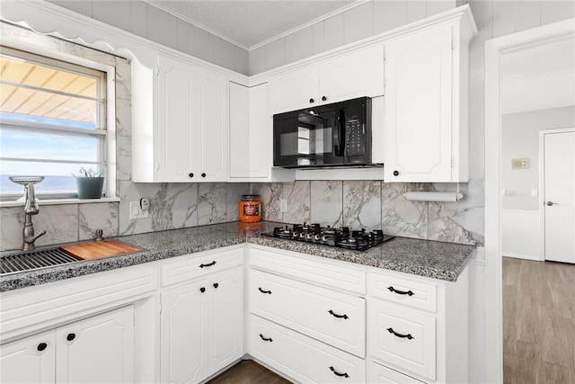 kitchen featuring sink, white cabinetry, crown molding, and black appliances