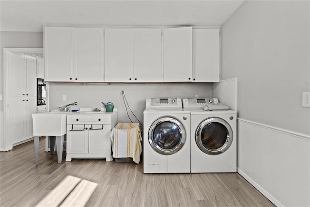 washroom with cabinets, light wood-type flooring, and independent washer and dryer