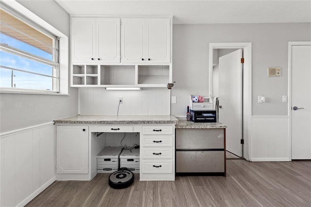 unfurnished office with light wood-type flooring and wooden walls