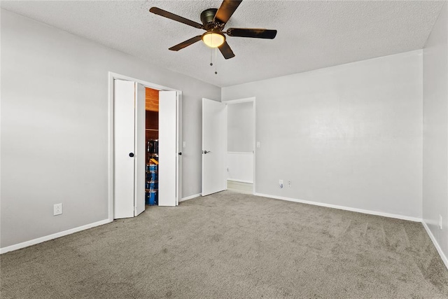 unfurnished bedroom with carpet, a textured ceiling, and ceiling fan