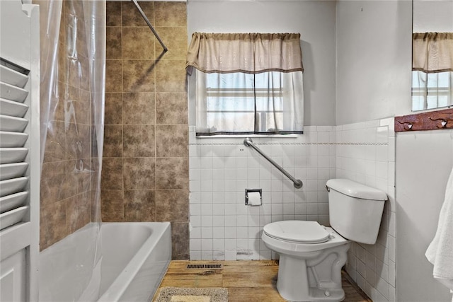 bathroom featuring toilet, tile walls, and shower / bath combo with shower curtain