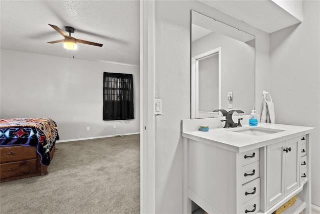 bathroom featuring vanity, ceiling fan, and a textured ceiling