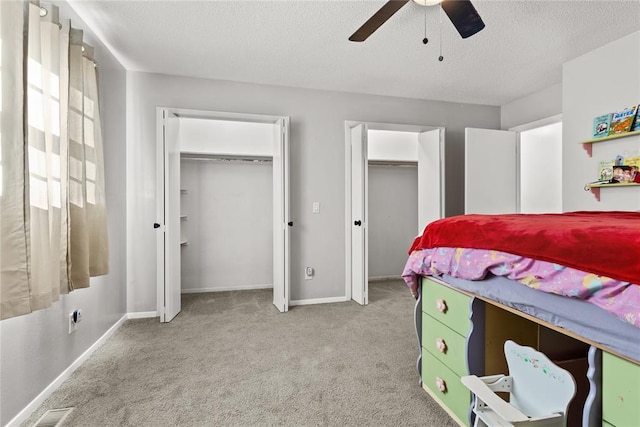 carpeted bedroom with a textured ceiling and ceiling fan