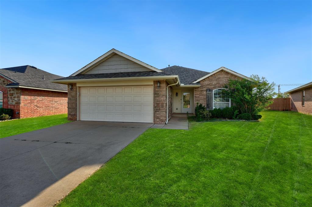 ranch-style home with a front lawn and a garage