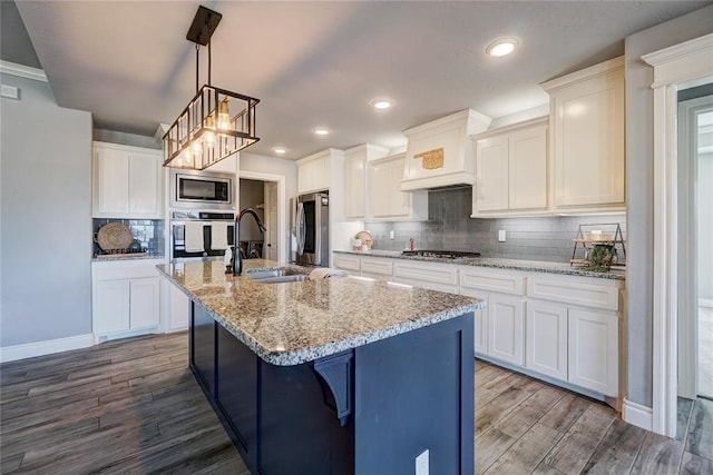 kitchen featuring a center island with sink, white cabinetry, and stainless steel appliances