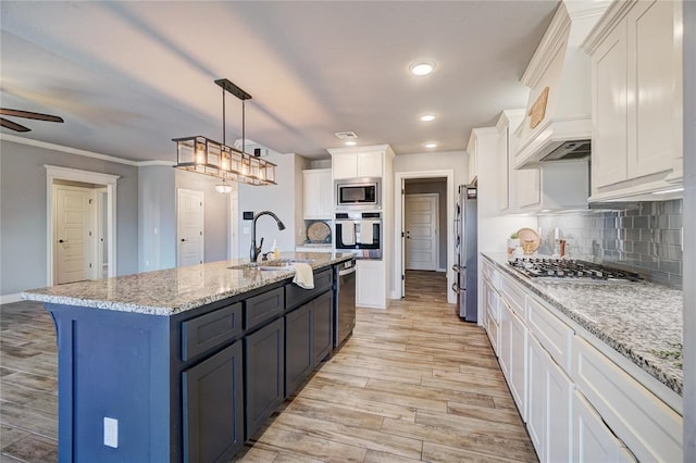 kitchen with stainless steel appliances, crown molding, light hardwood / wood-style floors, white cabinetry, and hanging light fixtures