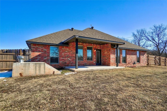 back of property with a yard and a patio area