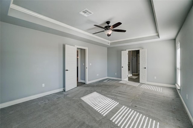 unfurnished bedroom featuring a raised ceiling, ceiling fan, and carpet floors