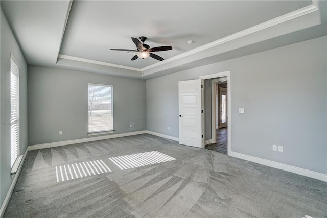 carpeted spare room featuring ceiling fan, a raised ceiling, and crown molding