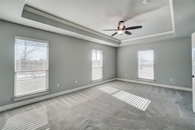 carpeted empty room featuring ceiling fan and a tray ceiling