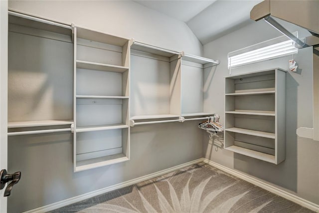 spacious closet with carpet flooring and lofted ceiling