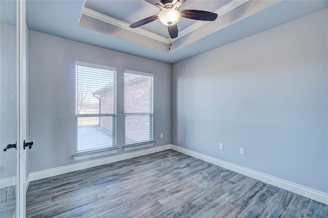 spare room with hardwood / wood-style floors, ceiling fan, a raised ceiling, and crown molding