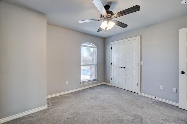 carpeted empty room featuring ceiling fan