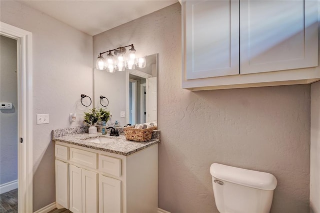 bathroom featuring vanity, toilet, and wood-type flooring