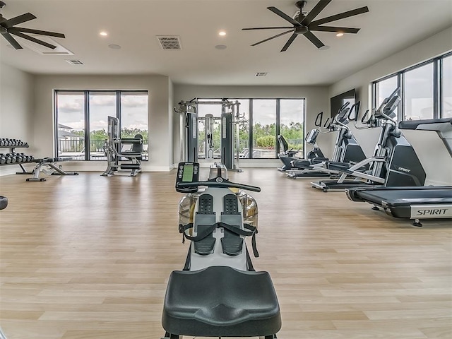 workout area with ceiling fan, a healthy amount of sunlight, and light wood-type flooring