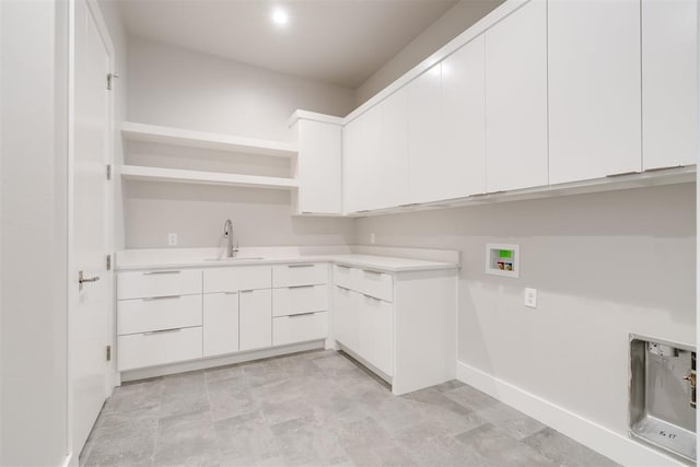 clothes washing area featuring cabinets, sink, and hookup for a washing machine