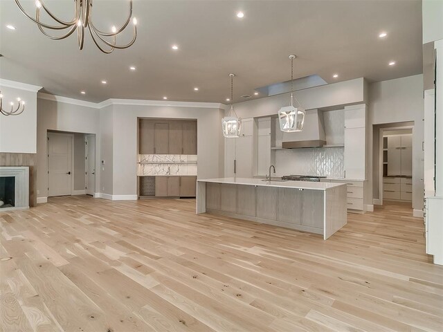 kitchen featuring tasteful backsplash, hanging light fixtures, a spacious island, and custom exhaust hood