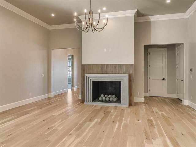 unfurnished living room featuring crown molding, light hardwood / wood-style flooring, and a chandelier