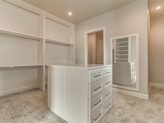 walk in closet with light carpet