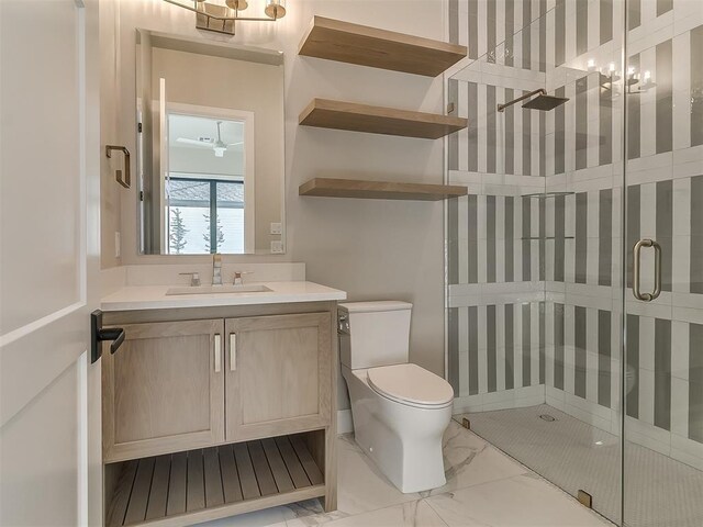 bathroom with a shower with door, vanity, and toilet