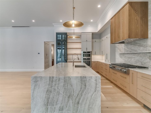 kitchen featuring a large island with sink, pendant lighting, backsplash, and appliances with stainless steel finishes