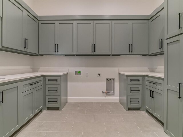 laundry area with washer hookup, cabinets, hookup for an electric dryer, gas dryer hookup, and light tile patterned flooring