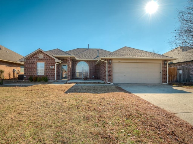 ranch-style house with a garage and a front lawn