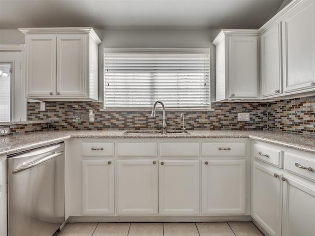 kitchen with white cabinetry, dishwasher, sink, tasteful backsplash, and light tile patterned flooring