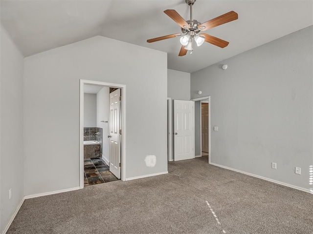 unfurnished bedroom with ensuite bathroom, ceiling fan, lofted ceiling, and dark carpet