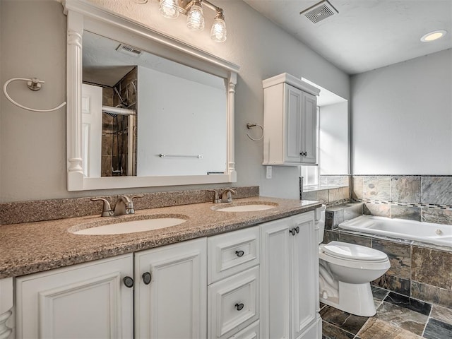 full bathroom featuring vanity, shower with separate bathtub, and toilet