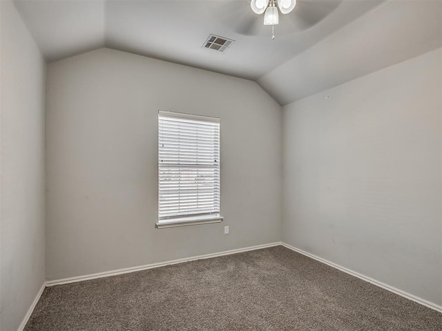 spare room featuring ceiling fan, carpet, and vaulted ceiling