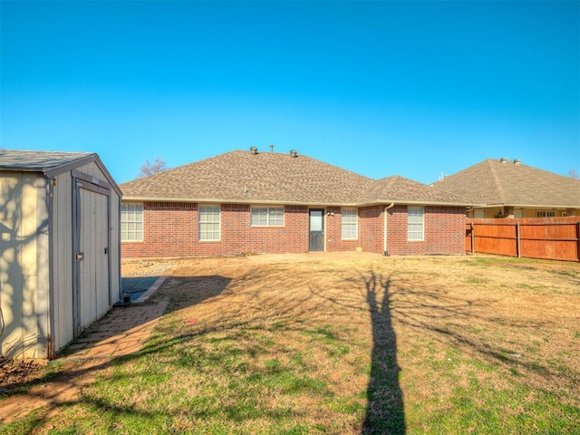 back of property with a yard and a storage shed