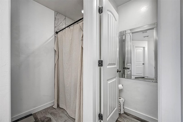 bathroom with a shower with shower curtain and wood-type flooring