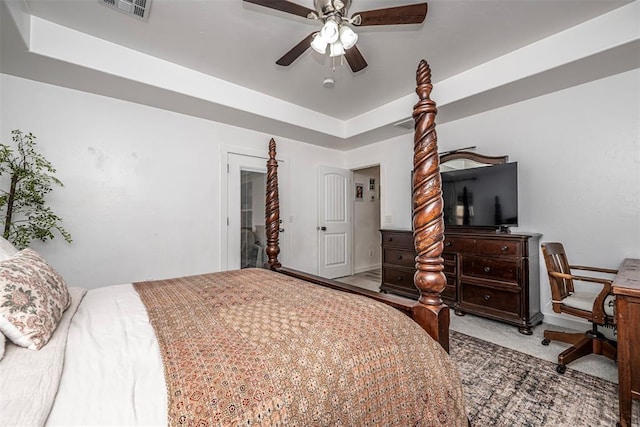 bedroom featuring carpet, a tray ceiling, and ceiling fan