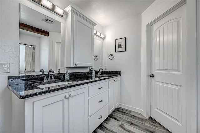 bathroom featuring hardwood / wood-style floors, vanity, and beamed ceiling