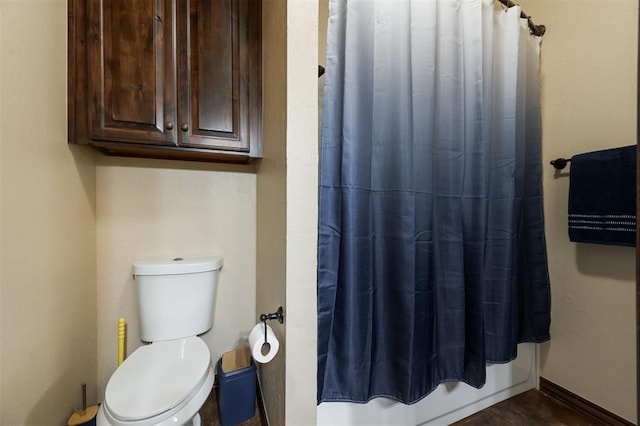 bathroom featuring a shower with curtain and toilet