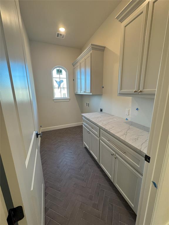 clothes washing area featuring cabinets, dark parquet flooring, hookup for a washing machine, and electric dryer hookup