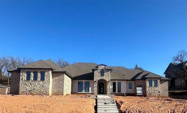 french country home with stone siding and stucco siding