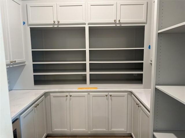 interior space featuring light stone counters and open shelves