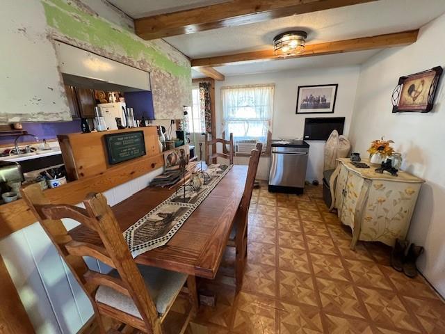 dining room featuring beam ceiling and light parquet flooring