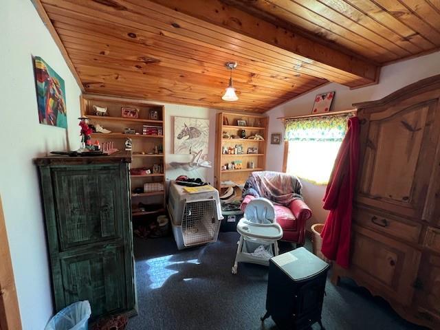 interior space featuring dark carpet, vaulted ceiling with beams, built in features, and wooden ceiling